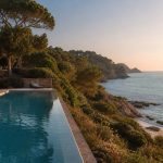 KI-generierte Klippenpool-Stimmung für das Can Simoneta in Canyamel mit historischem Naturstein, mediterranem Garten und Meerblick