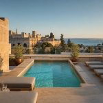 KI-generiertes Stimmungsbild für Es Príncep mit Rooftop-Pool, Palmes Altstadtmauern und Blick auf die Bucht