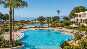 KI-Stimmungsbild für Grupotel Marítimo mit zwei Pools, mediterranem Garten und Blick zur Bucht von Alcúdia