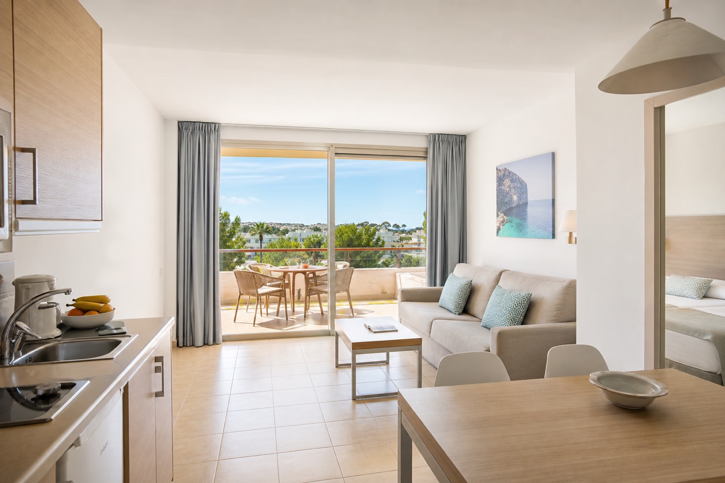 KI-Stimmungsbild für Grupotel Port d’Alcúdia mit Wohnbereich, Küchenzeile und großer möblierter Terrasse