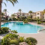 KI-Stimmungsbild für Grupotel Port d’Alcúdia mit großem Pool, Kinderbereich und mediterranem Apartmentgarten