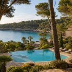 KI-Stimmungsbild für Hipotels Eurotel Punta Rotja mit Gartenpool, Pinien und ruhiger Bucht an der Costa dels Pins