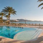 KI-Stimmungsbild für das Hipotels Flamenco mit renovierter Hotelarchitektur, Außenpool, Kinderbereich und direkter Strandlage