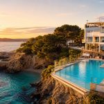 KI-Stimmungsbild für das Hotel Florida Magaluf mit Außenpool auf einer felsigen Landzunge, kleiner Badebucht und Abendsonne
