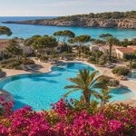 KI-Stimmungsbild für Iberostar Waves Cala Domingos mit Gartenbungalows, Pool und türkisfarbener Bucht