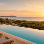 KI-Stimmungsbild für Iberostar Waves Cala Millor mit ruhigem Pool, Strand und Sonnenaufgang nahe Punta de n’Amer
