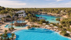 KI-Stimmungsbild für Iberostar Waves Club Cala Barca mit großer Poollandschaft, Kinderbereich und ruhiger Bucht bei Portopetro