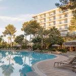 KI-generierter Außenpool im grünen Garten eines Familienhotels an der Playa de Palma