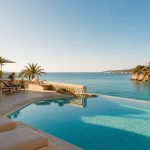 KI-generiertes Stimmungsbild für Nixe Palace mit elegantem Pool, Terrasse und direktem Blick auf den Strand von Cala Major