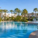 KI-generiertes Stimmungsbild einer großen Familienpoolanlage mit Splash-Bereich in Sa Coma für den Protur Badía Park Aparthotel Hotelcheck