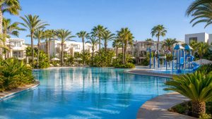 KI-generiertes Stimmungsbild einer großen Familienpoolanlage mit Splash-Bereich in Sa Coma für den Protur Badía Park Aparthotel Hotelcheck