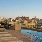 KI-generiertes Stimmungsbild eines modernen Rooftop-Pools über den Dächern von Palma als Symbolmotiv für das Protur Naisa Palma
