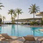 KI-generiertes Stimmungsbild einer palmengesäumten Poolanlage in Sa Coma für den Protur Sa Coma Playa Hotel und Spa Hotelcheck