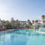 KI-generiertes Stimmungsbild einer modernen Familienpoolanlage mit Wasserspielbereich für den Protur Vista Badía Aparthotel Hotelcheck in Sa Coma