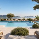 KI-Stimmungsbild für THB Bamboo Alcudia mit zwei modernen Pools, Sonnenterrasse und Blick auf eine Lagune