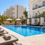 KI-generiertes Stimmungsbild eines kompakten Hotelpools mit Liegen und balinesischen Betten für den THB Niágara Hotelcheck an der Playa de Palma