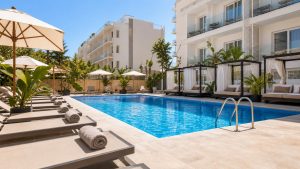 KI-generiertes Stimmungsbild eines kompakten Hotelpools mit Liegen und balinesischen Betten für den THB Niágara Hotelcheck an der Playa de Palma