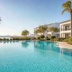 KI-Stimmungsbild für das Universal Aparthotel Elisa mit Außenpool, mediterranen Apartmentgebäuden und Lagunenlandschaft bei Playa de Muro