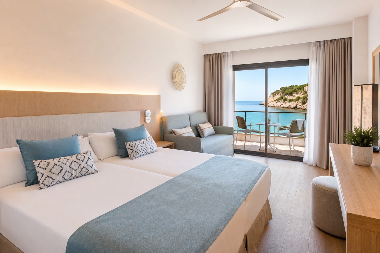 KI-Stimmungsbild für das Universal Hotel Castell Royal mit hellem Familienzimmer, Schlafsofa und Balkon über der Bucht von Canyamel