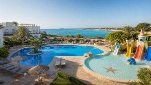 KI-Stimmungsbild für das Universal Hotel Romántica mit Hauptpool, flachem Kinderpool, Wasserrutschen und Südmallorca-Küste