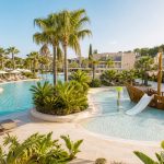 KI-generierte Familienpool-Stimmung für das Zafiro Palace Palmanova mit Palmen, großem Resortpool und flachem Kinderbecken mit Spielelement