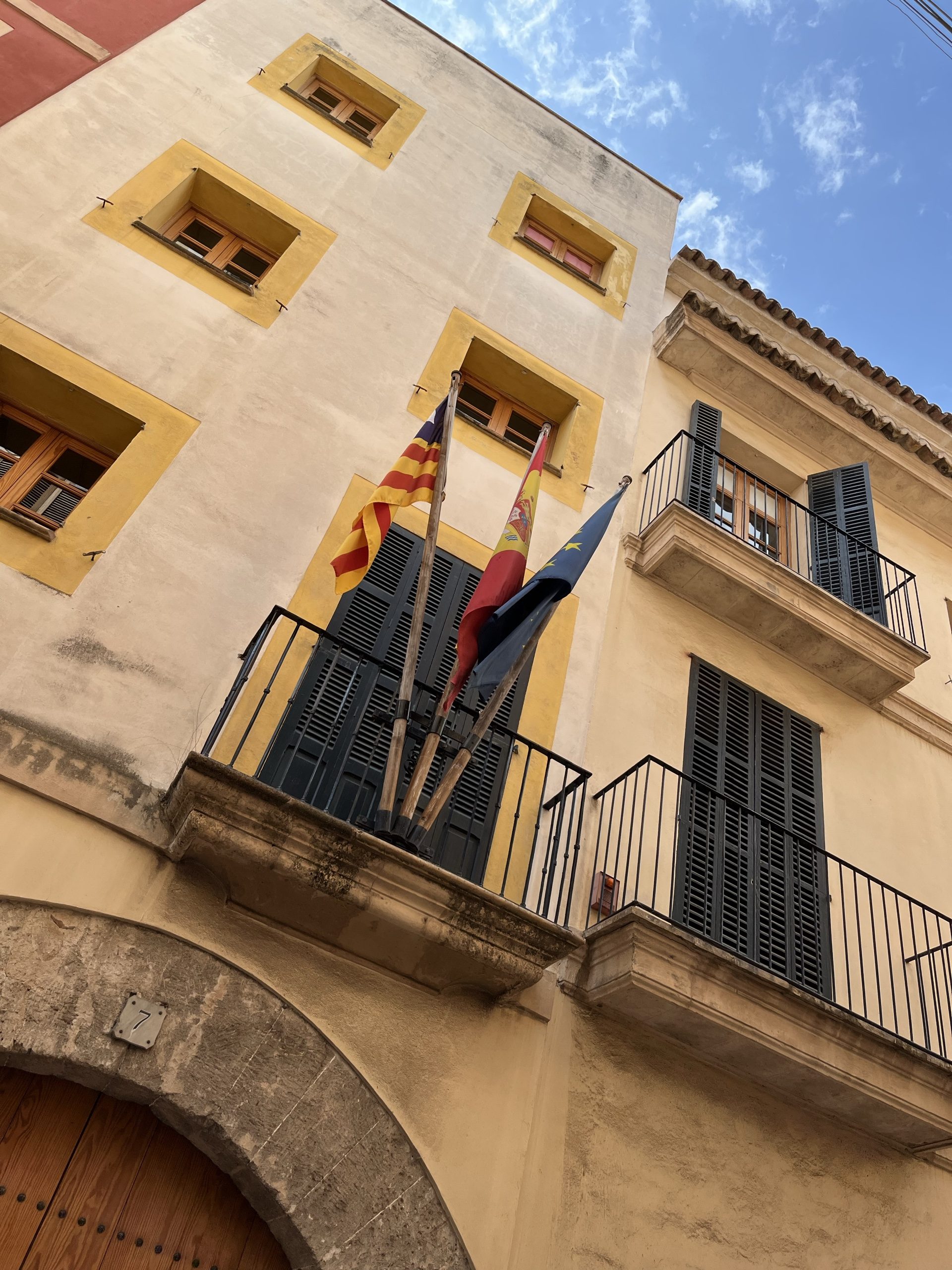 Historische Fassade mit Balkon und Flaggen in Palma